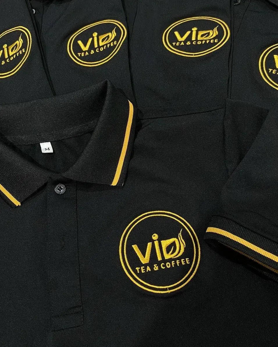 Schwarze Poloshirts mit goldener Logostickerei auf der Brust für einen Gastronomiebetrieb