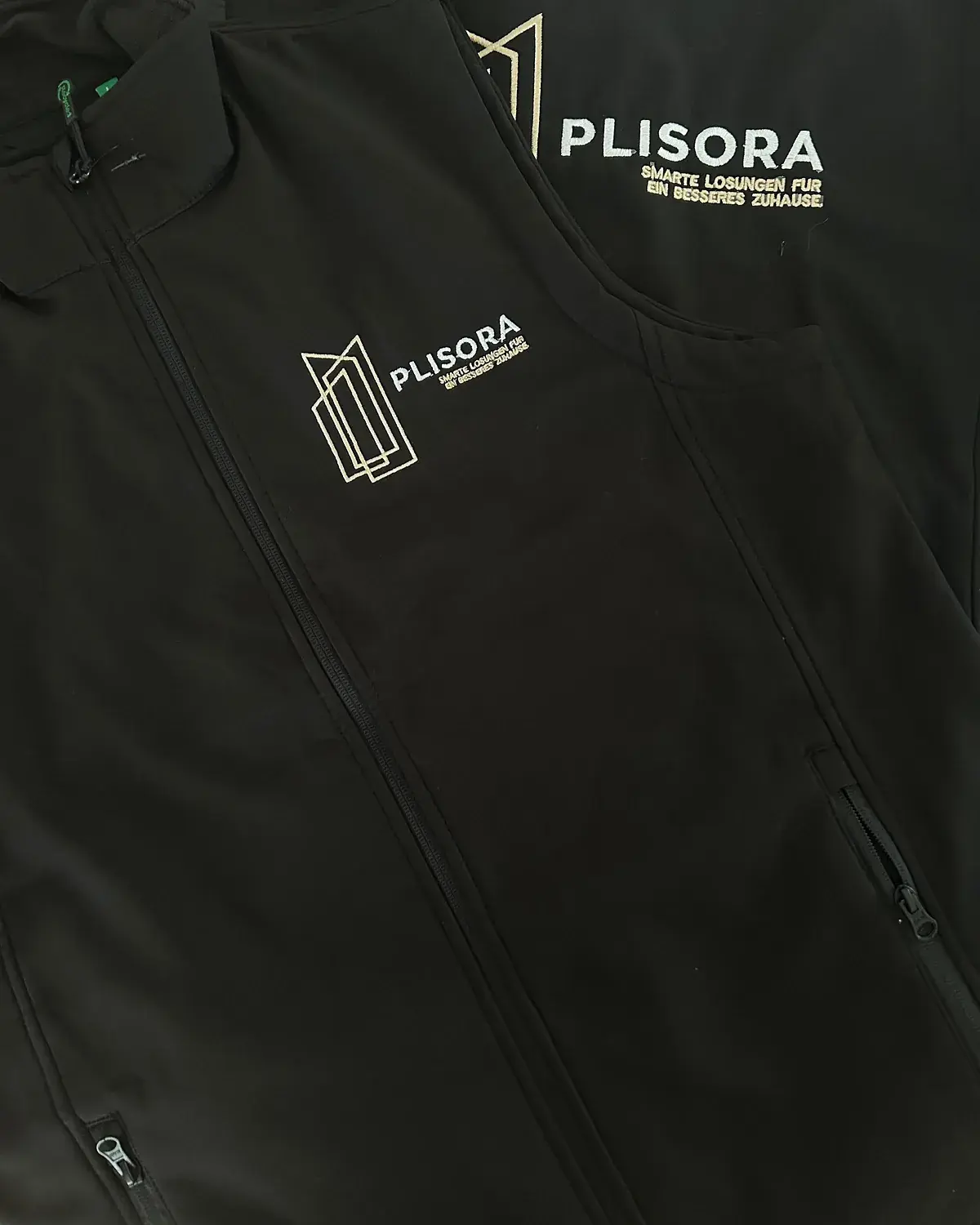 Bestickte schwarze Softshelljacke mit Firmenlogo auf Brust und Schulter